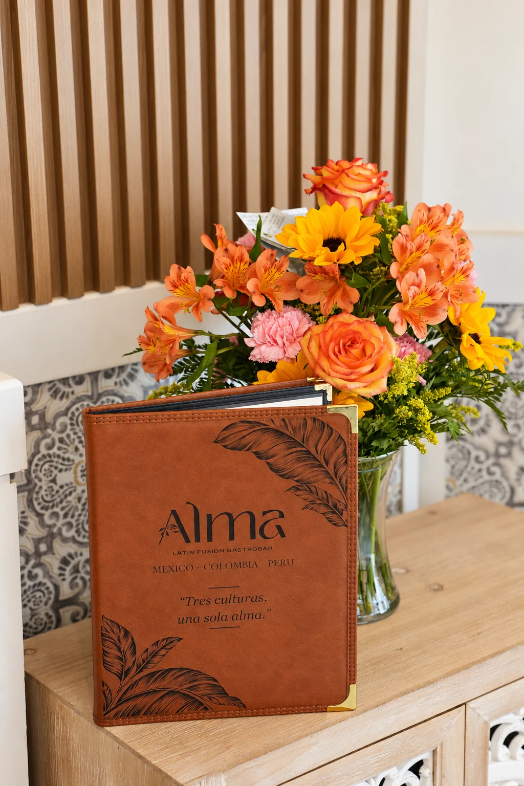 ALMA menu beside a floral arrangement